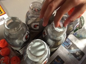 Drop in a couple of marbles--that way, you can just shake the bottles to mix the paint up when you need it. 